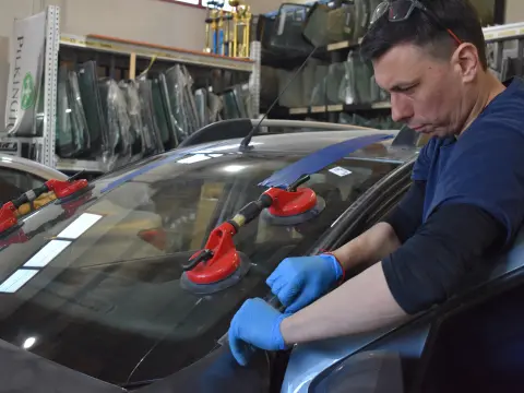 Técnico trabajando sobre el parabrisas de un vehículo